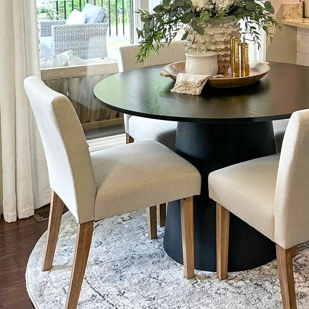 North Upholstered Dining Chair, light fabric, wood legs, dark round table, elegant dining room setting.