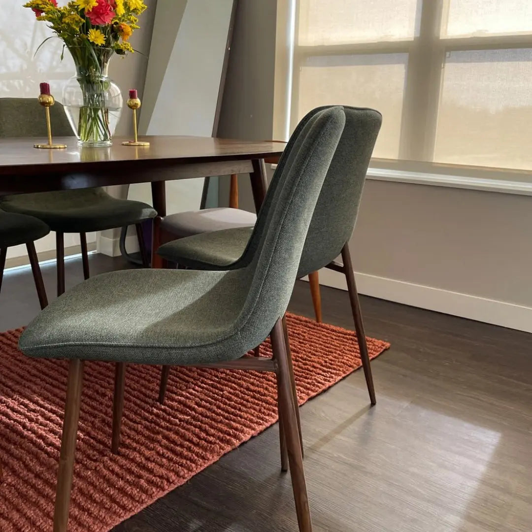 Oslo Modern Upholstered Dining Chair with walnut legs in elegant dining room, dark wood flooring.