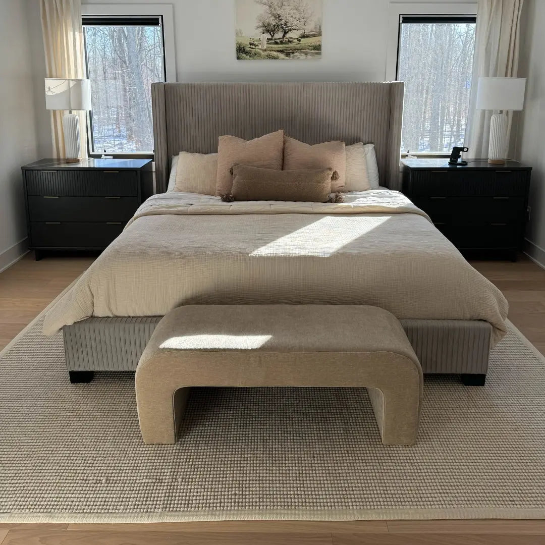 Elegant Lily Chenille Accent Waterfall Bench in beige bedroom with wooden flooring and modern decor.