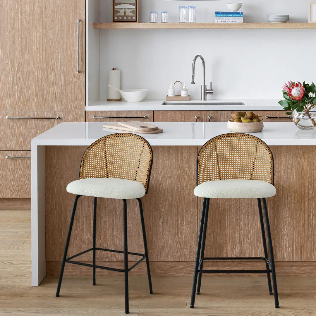 Jules Modern Upholstered Rattan Counter Stool in kitchen with wood cabinets and white countertop.