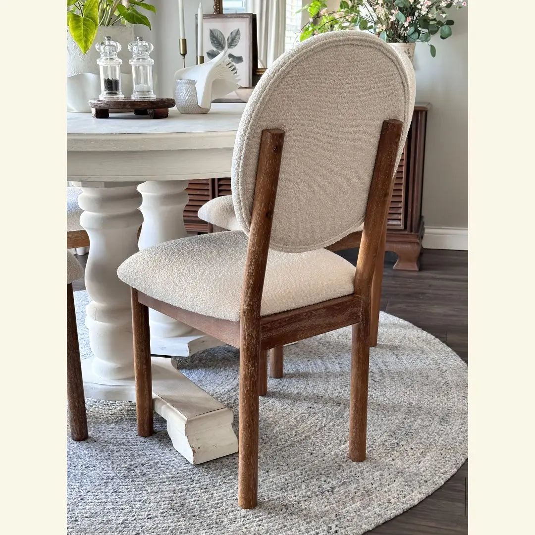 Maye Boucle dining chair in beige, with white round table on gray carpet, wooden floor dining room.