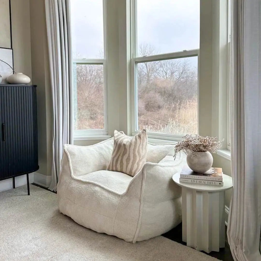 Boring Upholstered Teddy Fabric Bean Bag Chair in cozy living room with cream carpet and black cabinet.