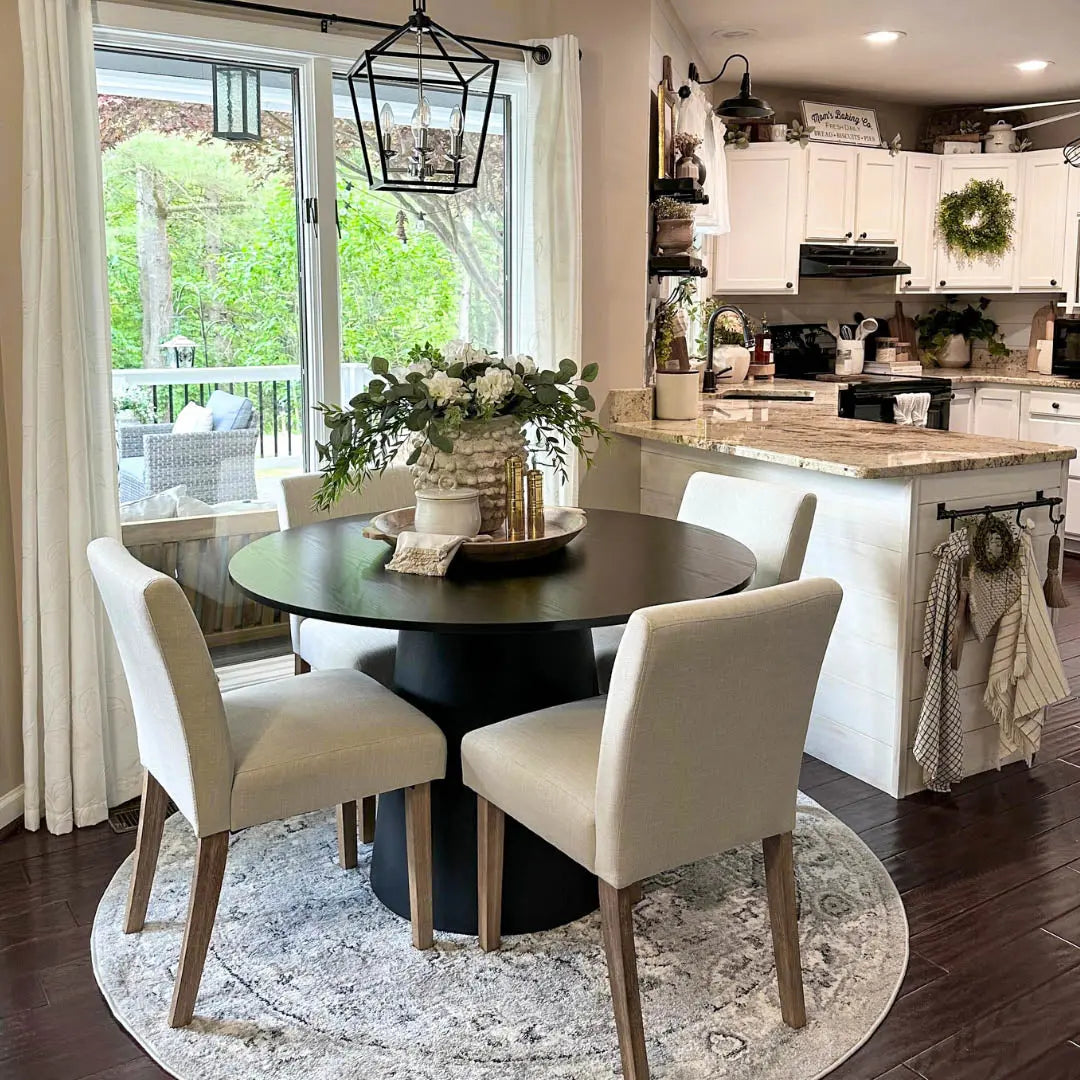 North Upholstered Dining Chair in kitchen with dark round table, hardwood floor, light cabinets.