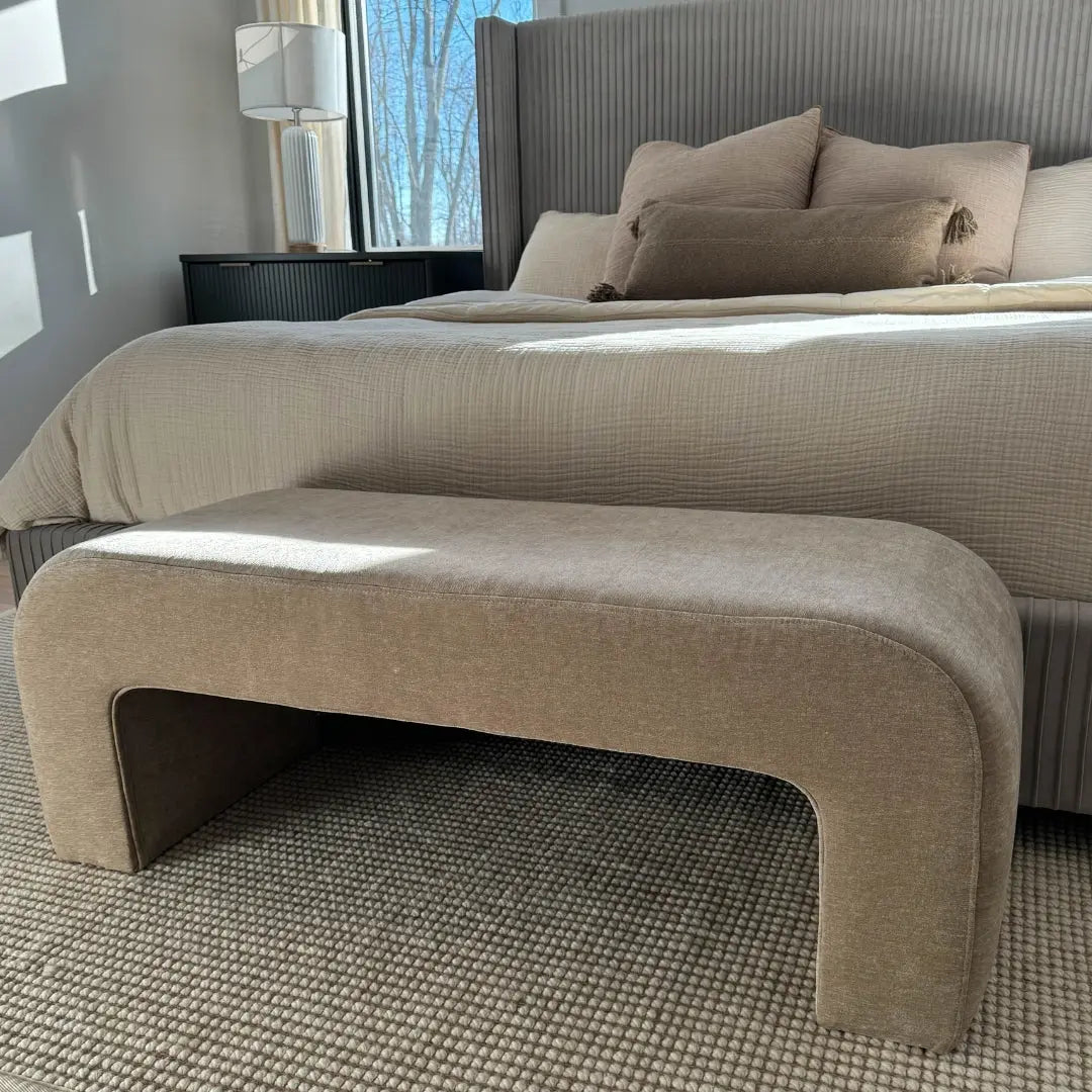 Lily Chenille Accent Waterfall Bench in bedroom with textured carpet, neutral bed, grey walls.