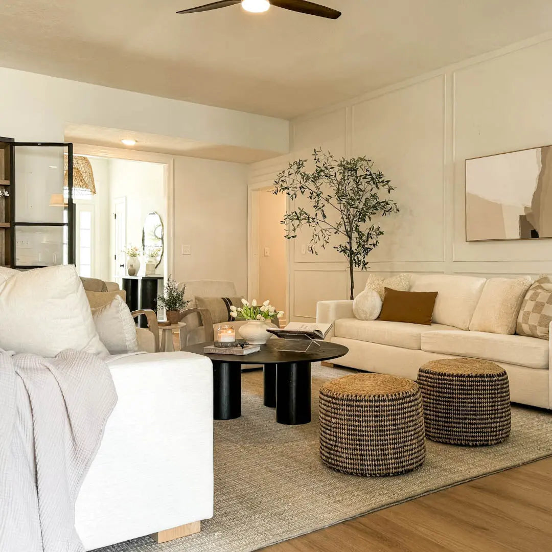 Baguette Black Oak Coffee Table in cozy living room with cream sofas, beige walls, wicker stools.