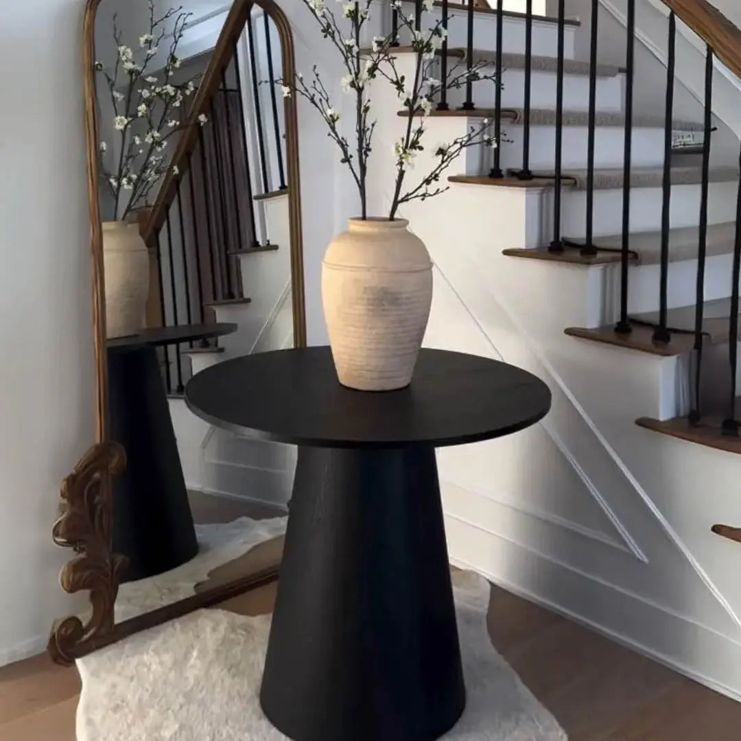 Dwen Modern Round Pedestal Dining Table by stairs, mirror reflection, and white wall design.