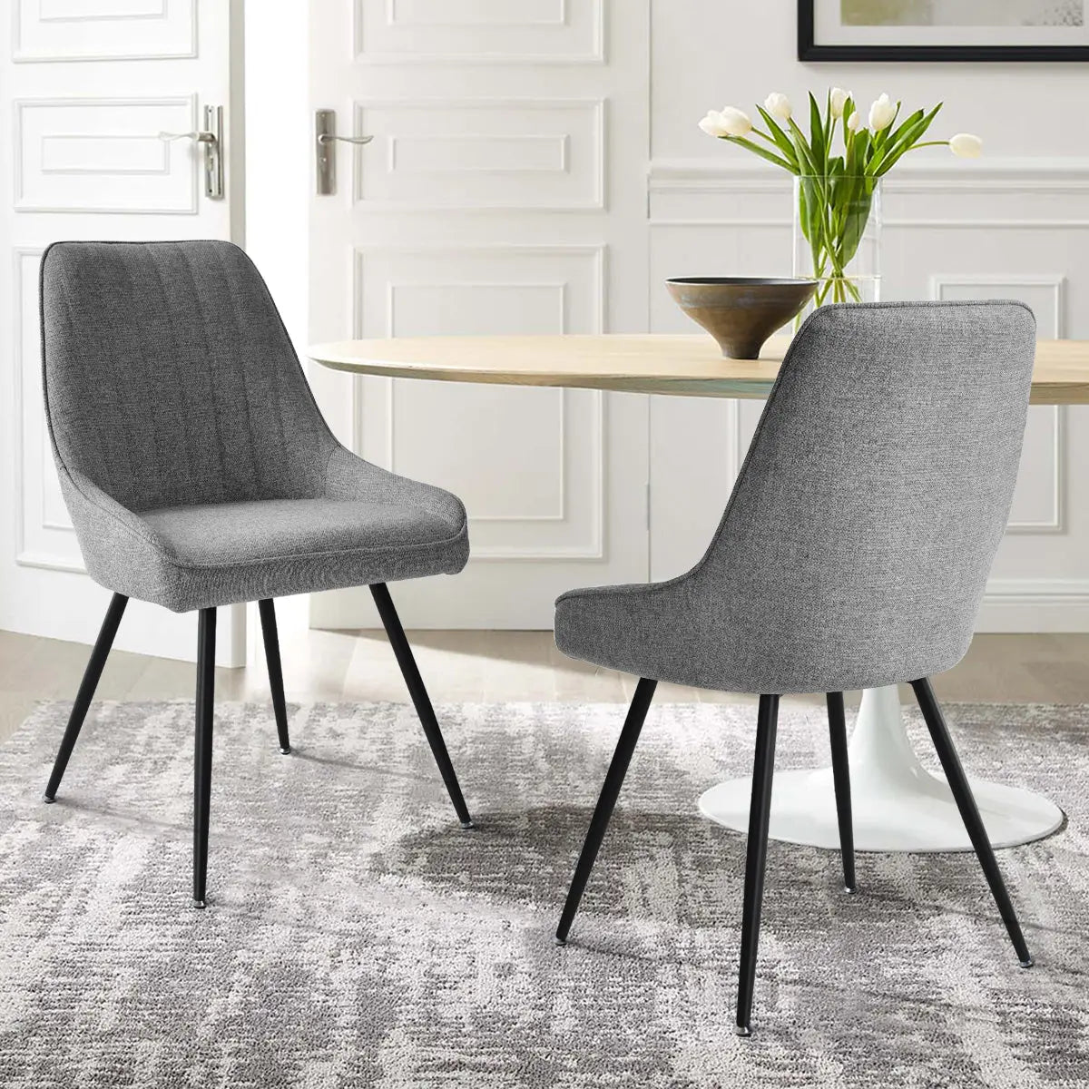 Boston Modern Upholstered Dining Chair, gray fabric, black legs, white dining room, wooden round table.