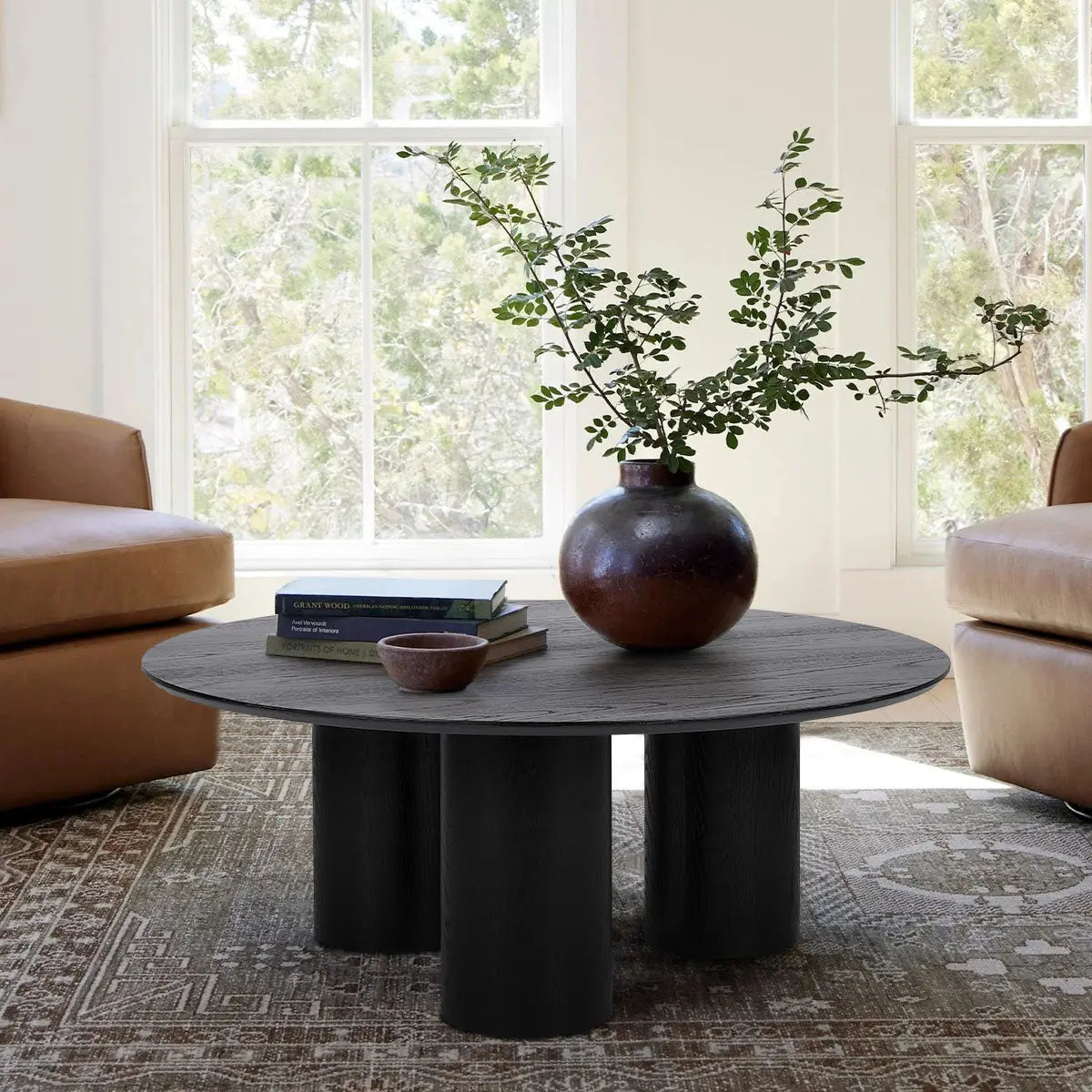 Baguette 40" black oak coffee table in living room with brown leather sofas, neutral carpet.