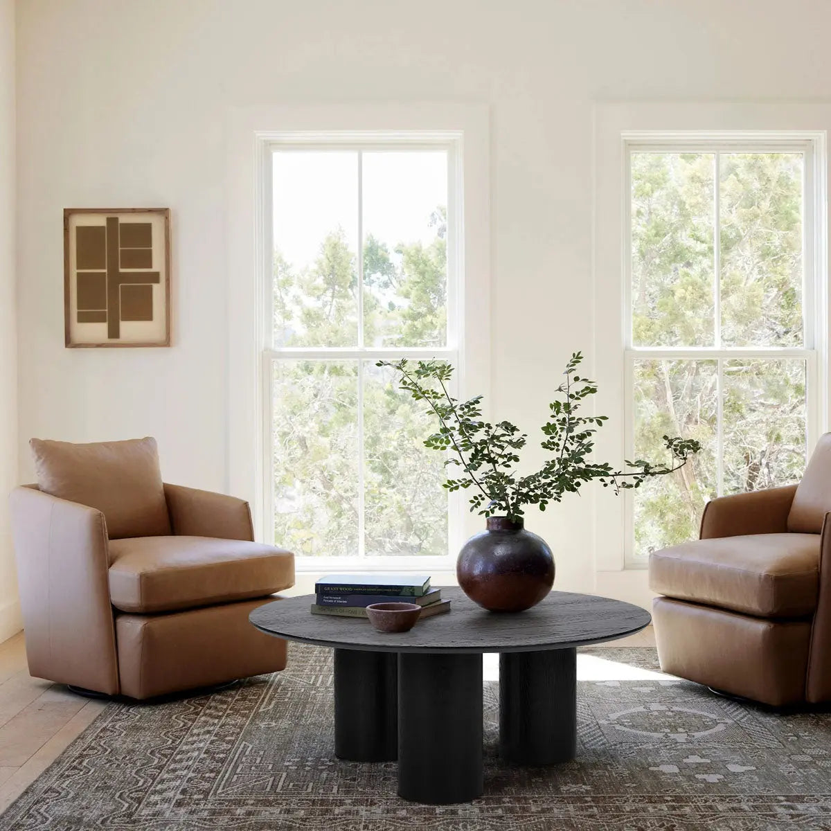 Beige armchairs with Baguette Modern Black Oak Coffee Table, rustic rug, and cream walls in cozy living room.