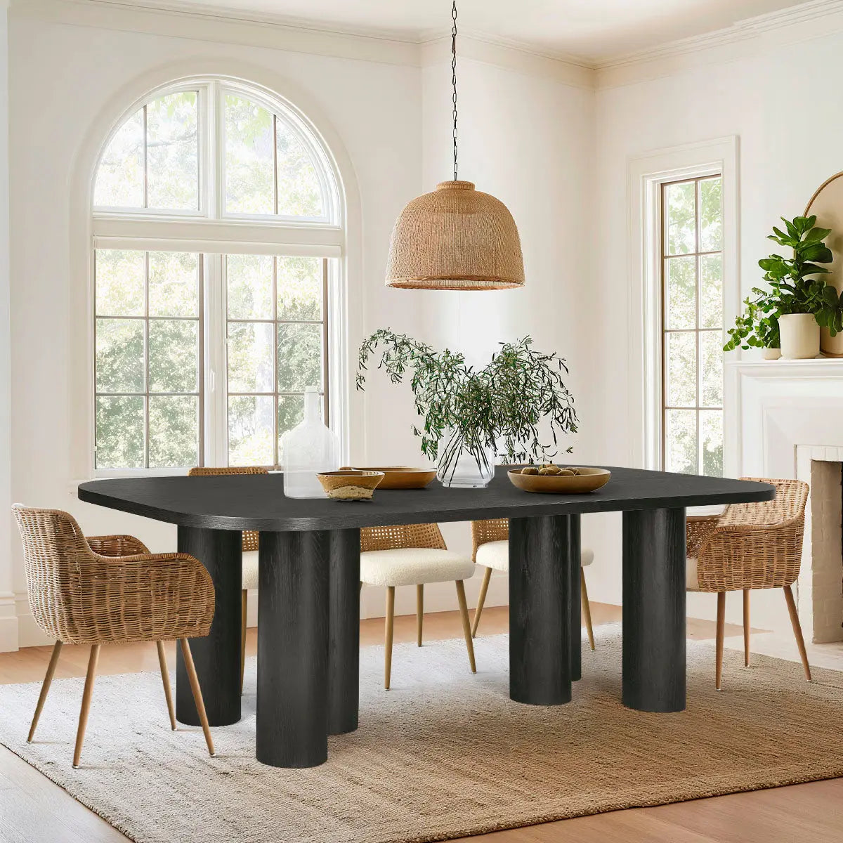 Oak dining table in modern room with wicker chairs, neutral walls, and large windows.