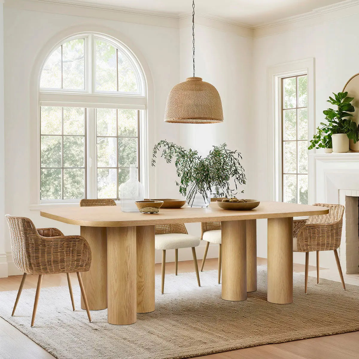 Baguette oak dining table in bright room with wicker chairs, beige rug, light walls, and windows.