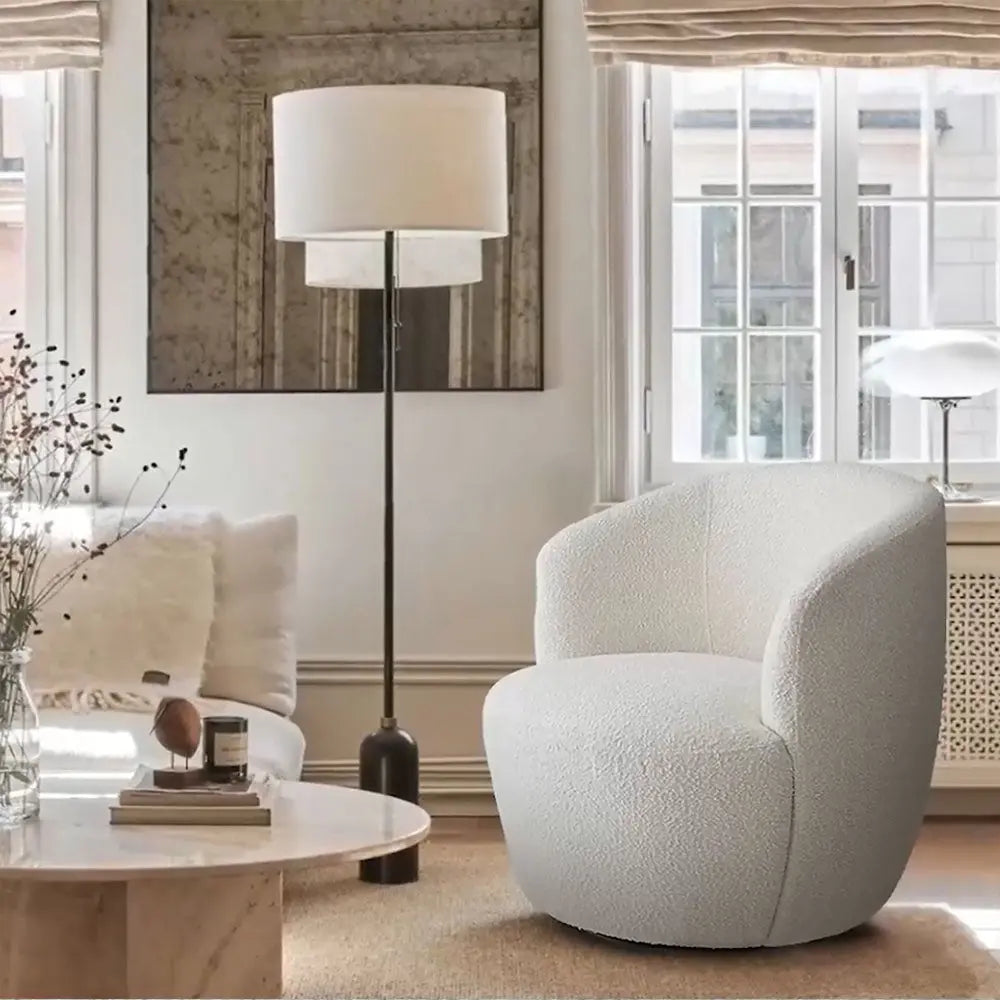 Bella Modern White Boucle Swivel Barrel Chair in cozy room with modern decor and beige carpet.