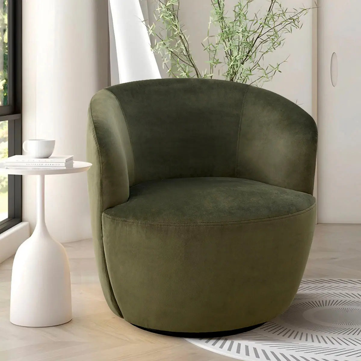 Bella Modern Olive Green Velvet Swivel Barrel Chair, in bright room with white side table.