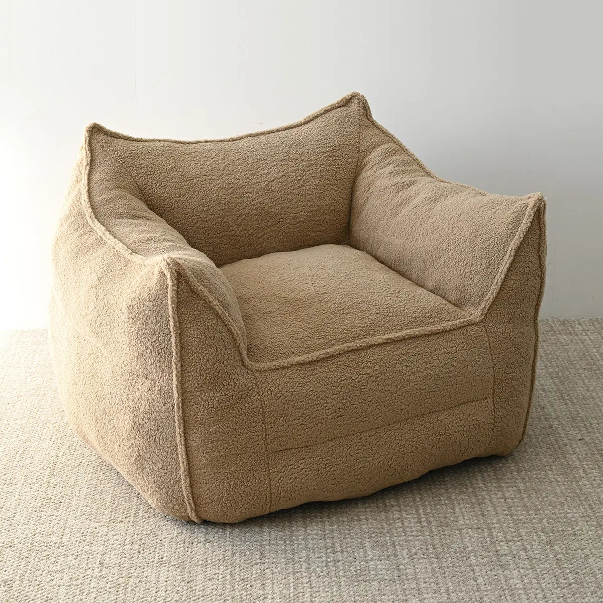 Boring Upholstered Teddy Fabric Bean Bag Chair on textured carpet in minimalistic room setting.