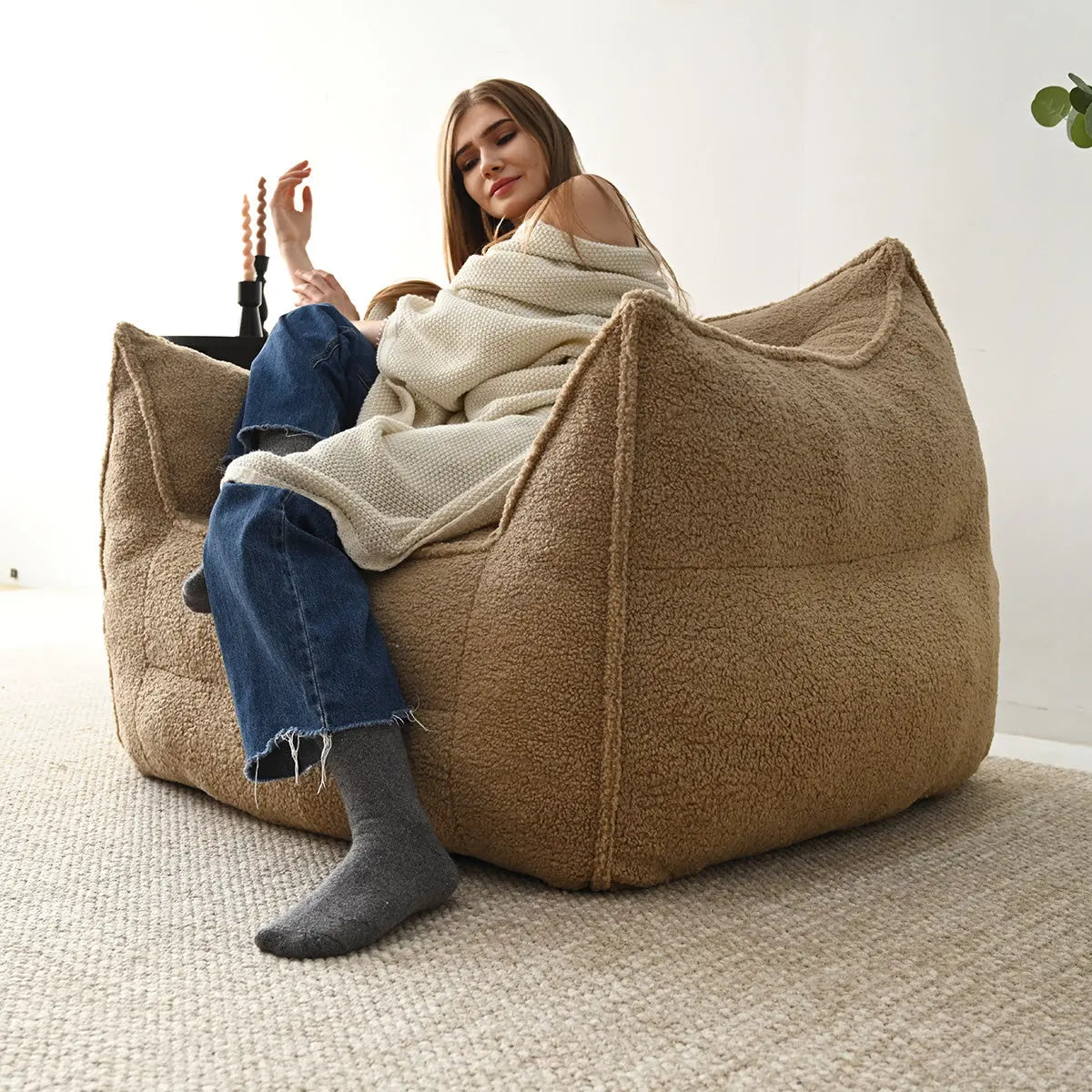 Boring Upholstered Teddy Fabric Bean Bag Chair in cozy room with beige rug, woman relaxing.