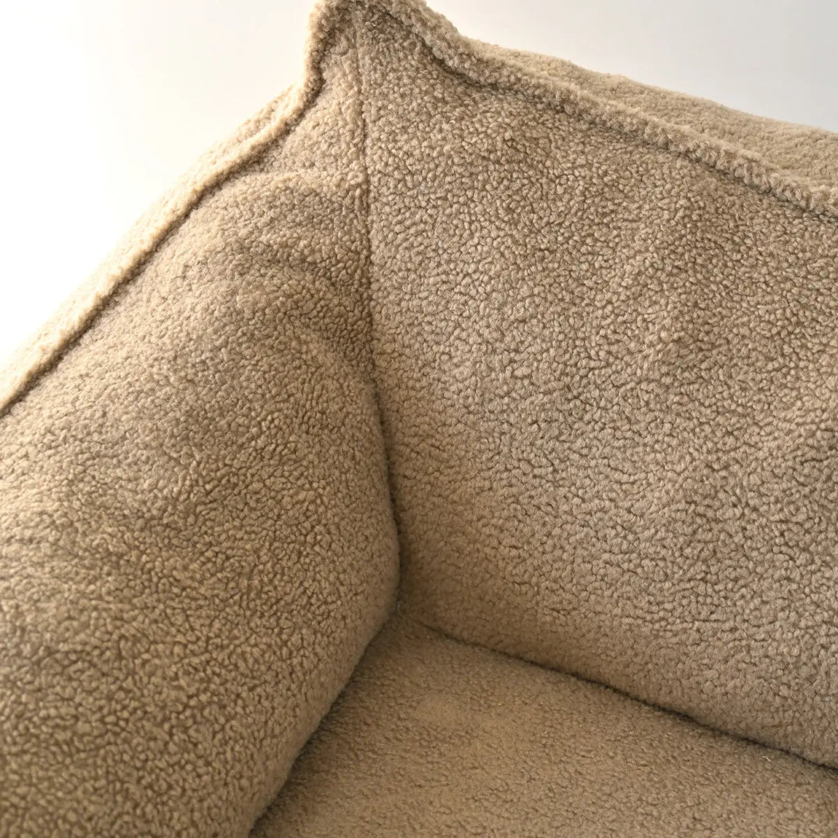 Close-up texture of Boring Large Teddy Fabric Bean Bag Loveseat Sofa in beige, cozy furniture detail.