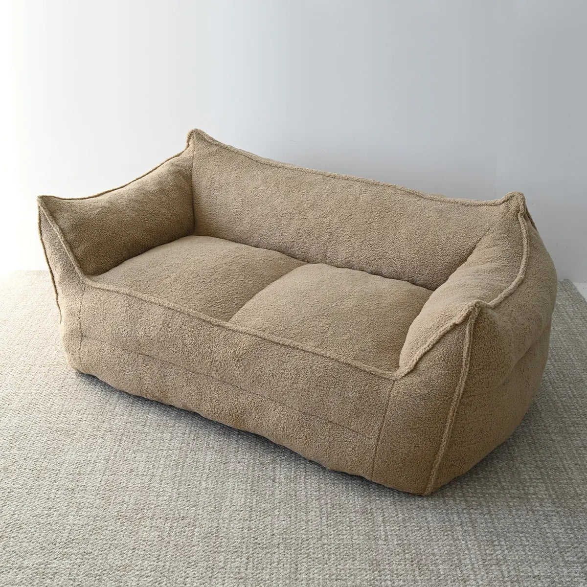 Boring Large Teddy Fabric Bean Bag Loveseat Sofa on textured carpet in minimalist room setting.