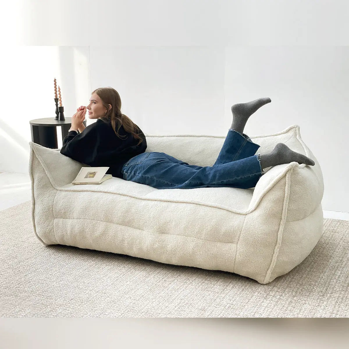 Boring Large Teddy Fabric Bean Bag Sofa in neutral room with dark side table and light carpet.