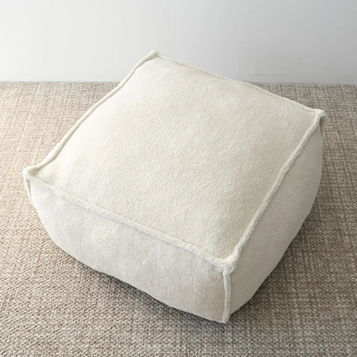 Boring Teddy Fabric Bean Bag Chair on beige carpet, minimalist living room setting.