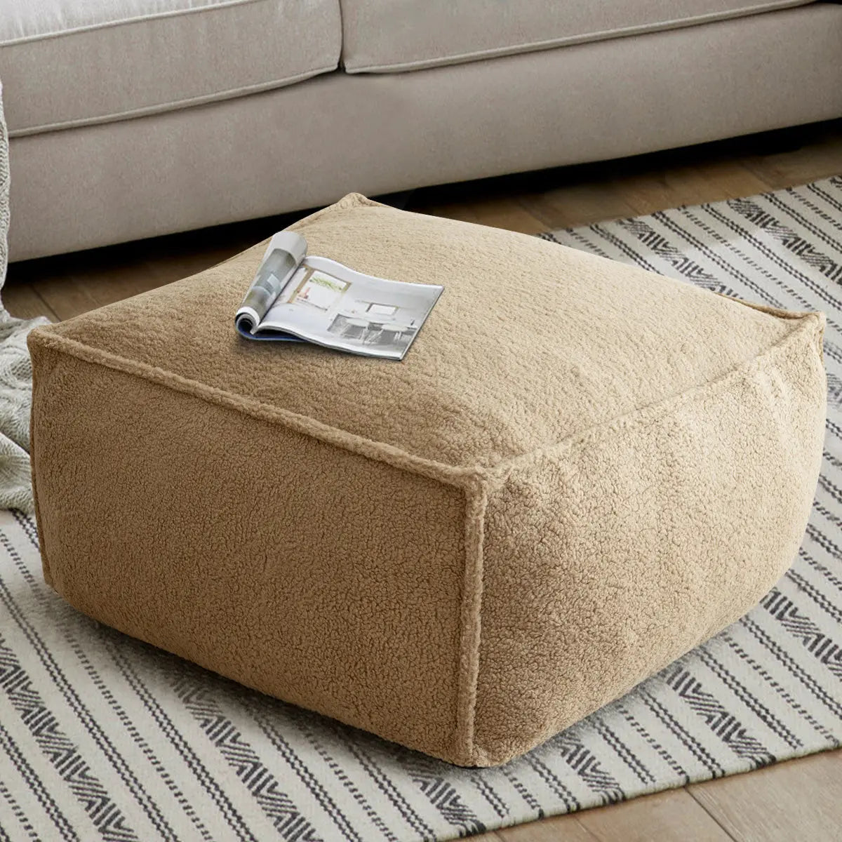 Boring Teddy Fabric Square Bean Bag Ottoman with sofa, patterned rug, wooden flooring in living room.