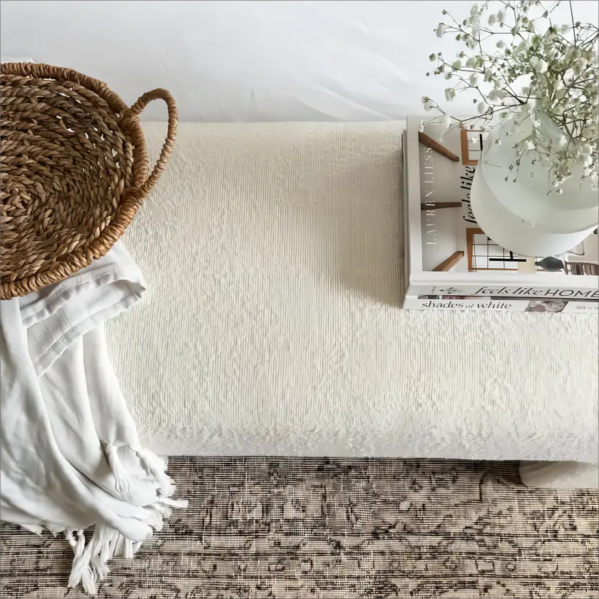 Lily Modern Velvet Accent Waterfall Bench on patterned rug with woven decor, neutral room setting.