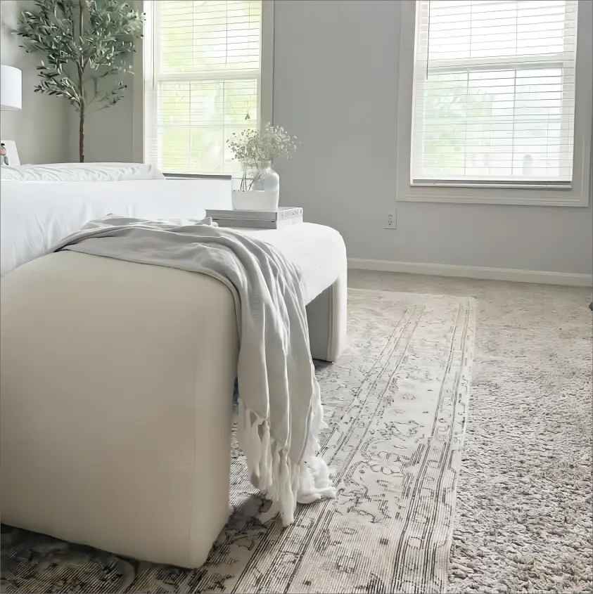 Modern velvet accent waterfall bench in cozy living room with soft carpet and neutral walls.