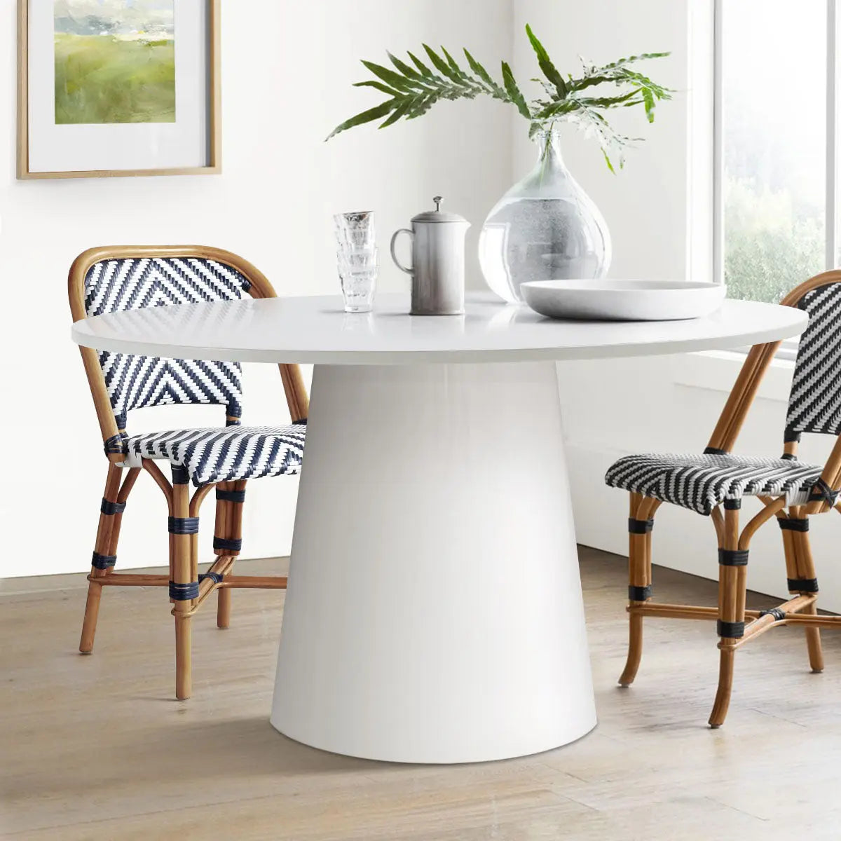 Dwen Modern Round Pedestal Dining Table, white room, patterned chairs, light wood flooring, wall art.