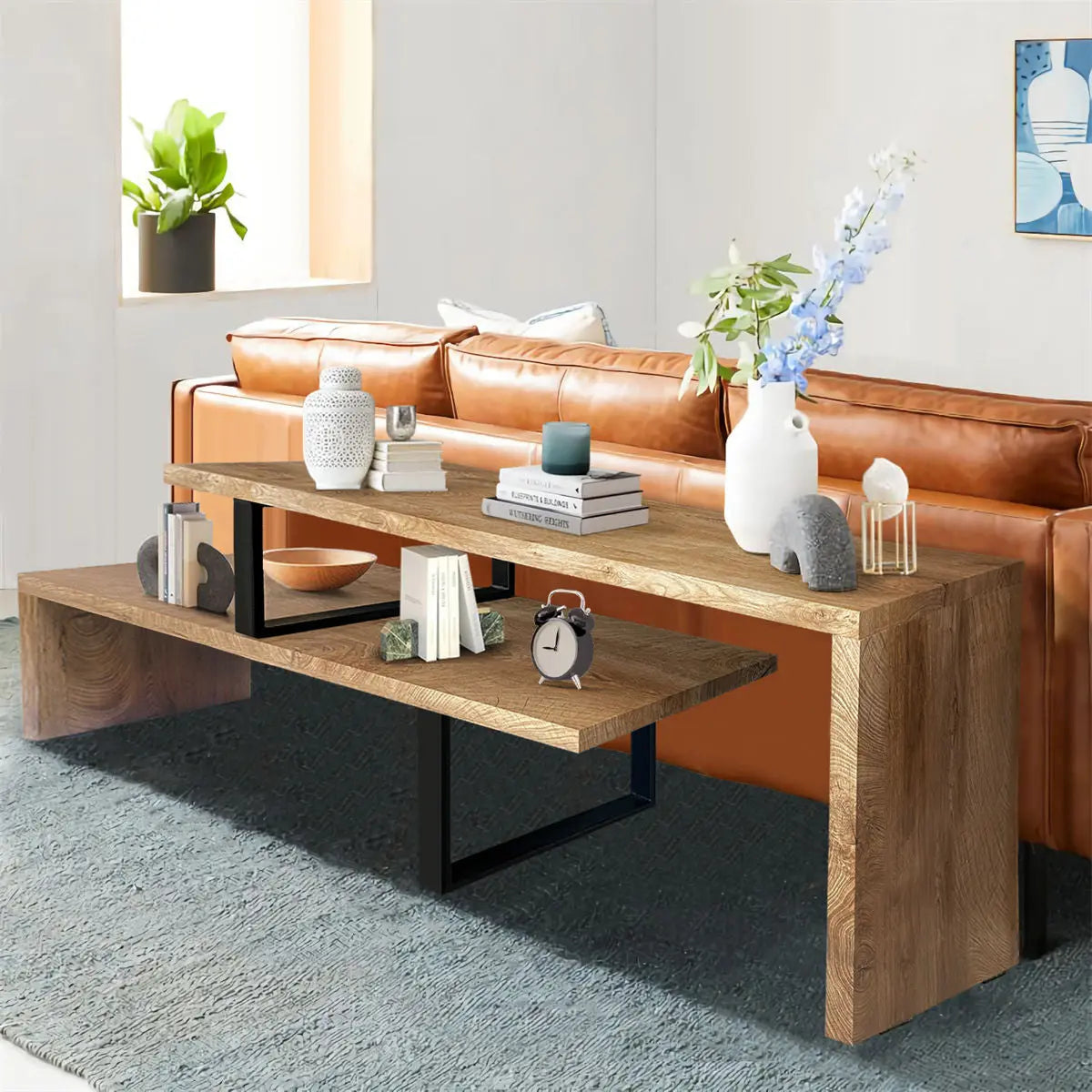 Multifunctional wooden console table behind brown leather sofa in cozy room with gray carpet and decor.