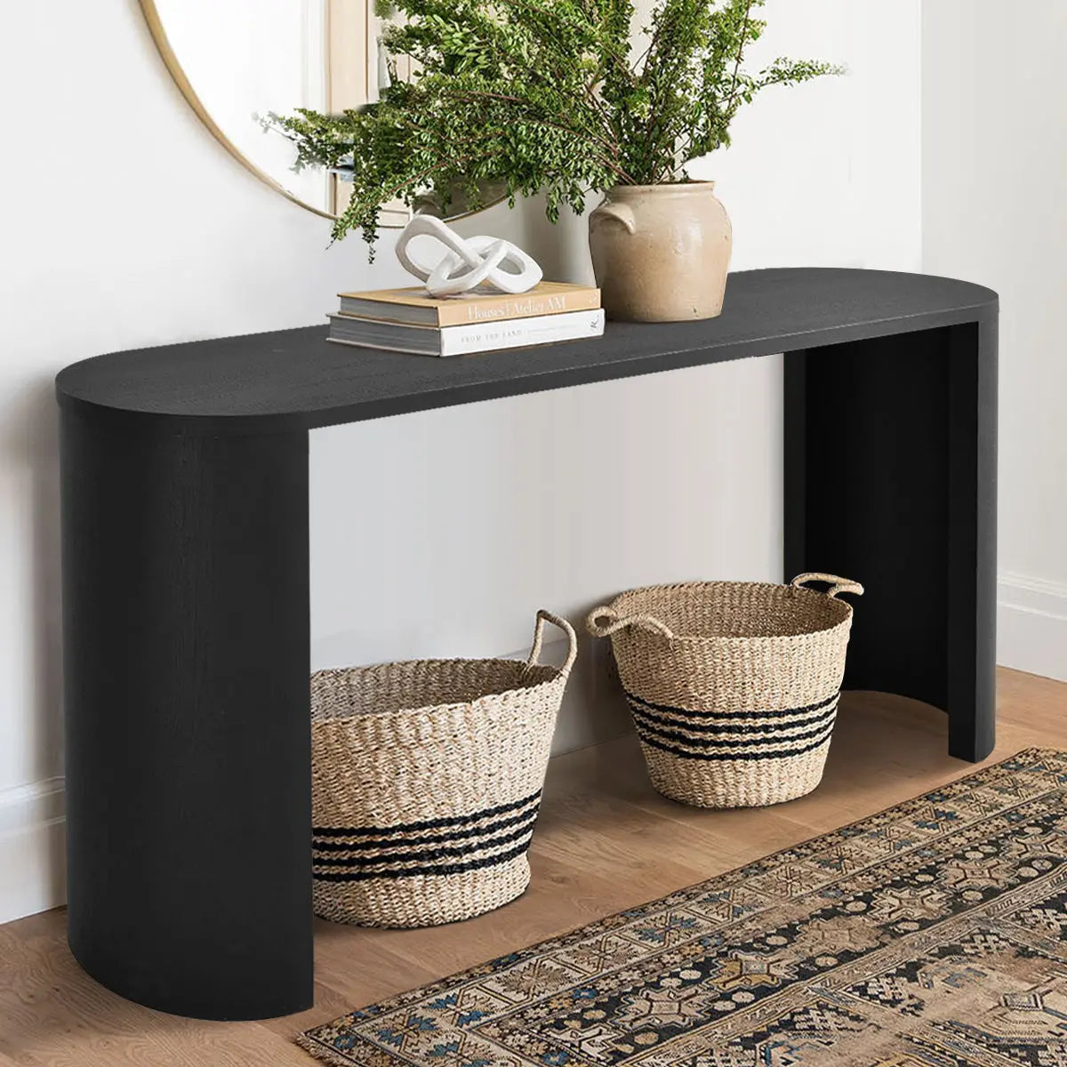 Dwen Modern Oval Console Table, black with woven baskets, light wood flooring, patterned rug.