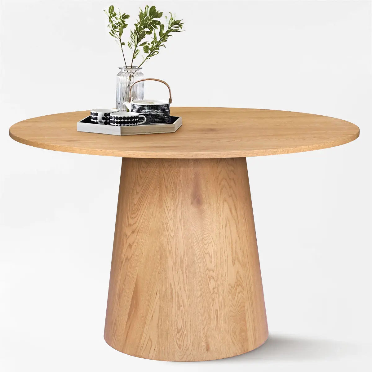 Dwen Modern Round Pedestal Dining Table, light wood finish, minimalist design, with decor tray.