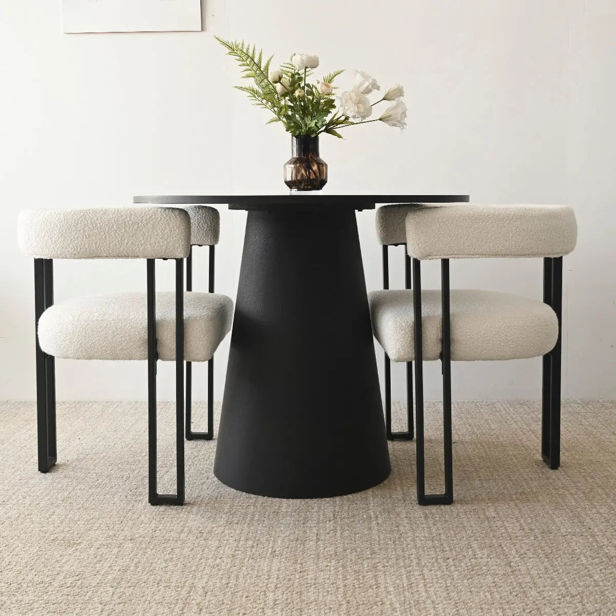 Dwen & Mia Black Beige Dining Table Set, beige upholstered chairs, textured carpet, minimalist white wall.