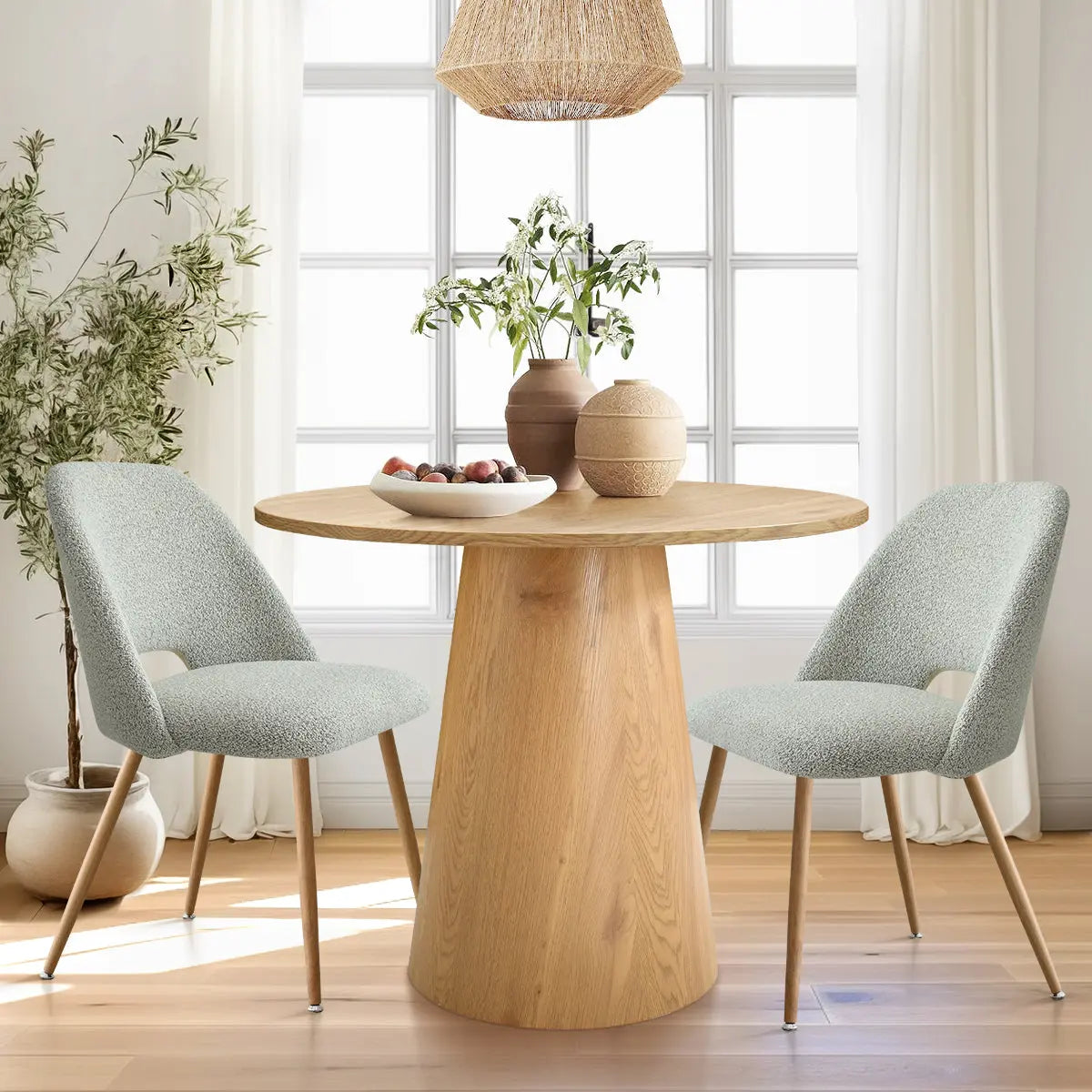 Dwen & Edwin round dining table set with light wood chairs, hardwood flooring, and large windows.