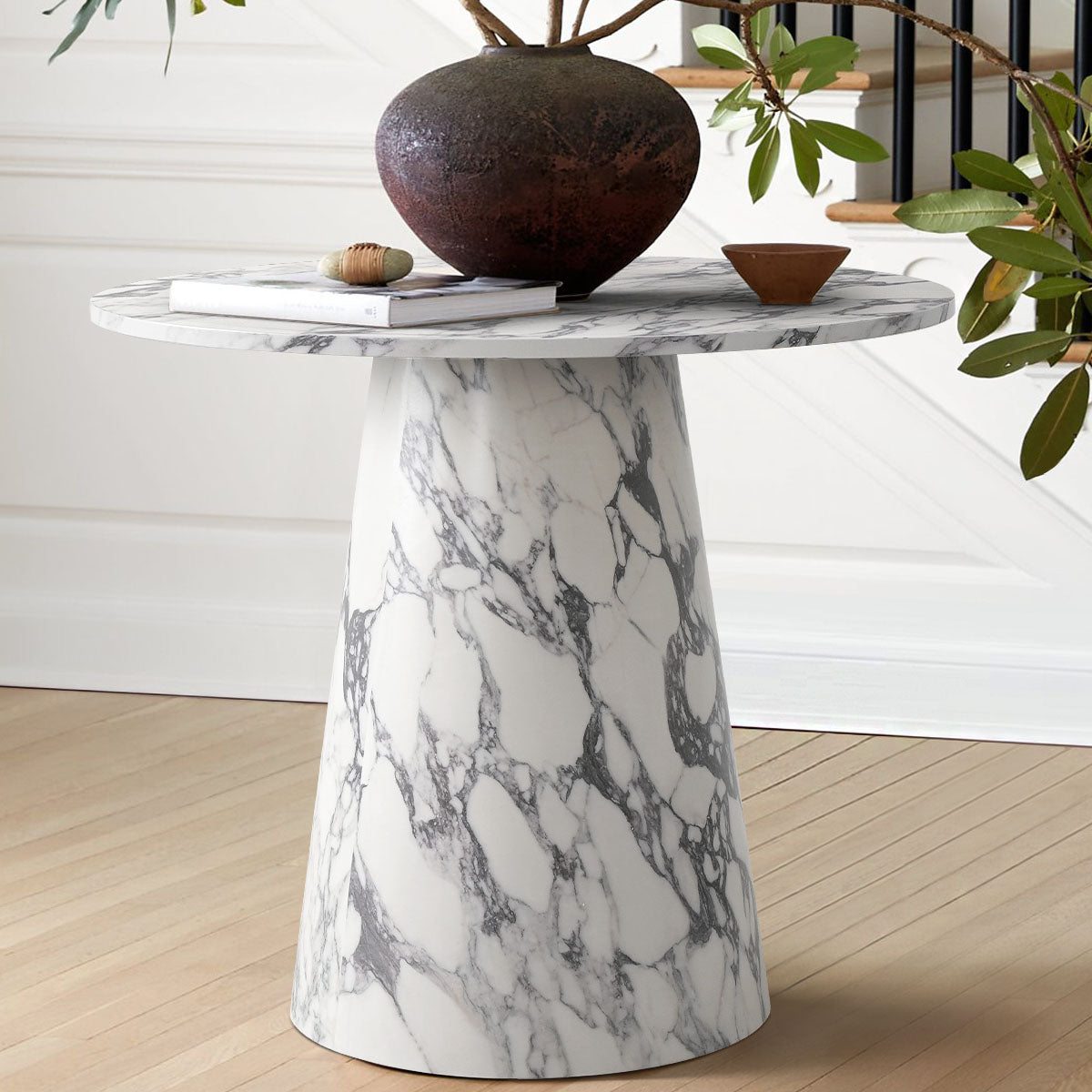 Dwen 35" faux marble dining table with wood flooring, white panel walls, and decorative bowl on top.