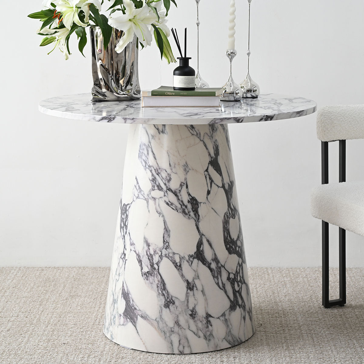 Dwen Modern Marble Round Pedestal Dining Table with off-white chair and beige carpet flooring.