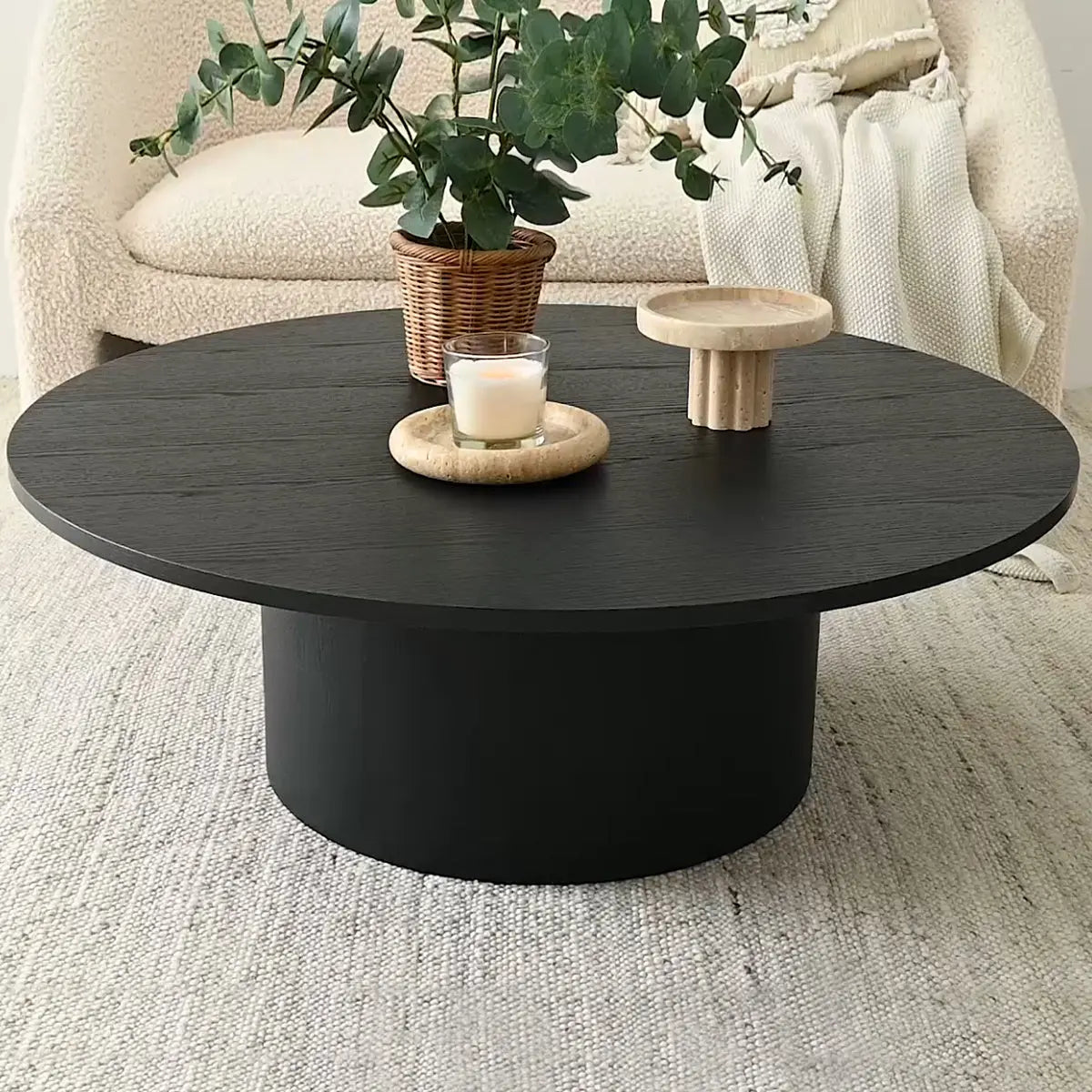 Dwen Modern Round Pedestal Coffee Table in cozy living room with beige sofa, textured rug.