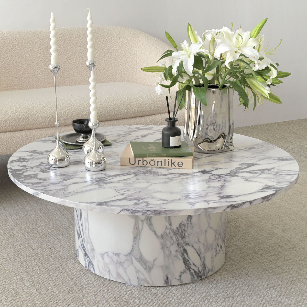 Dwen Modern Marble Round Pedestal Coffee Table in living room with beige sofa, carpet flooring.