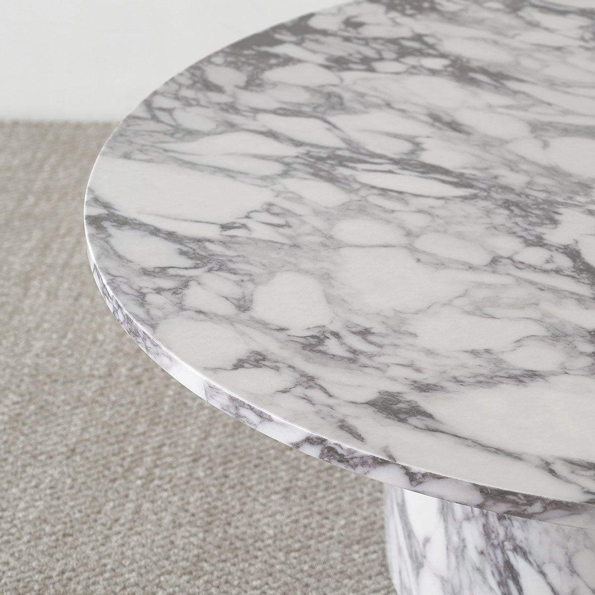 Dwen Modern Marble Round Pedestal Coffee Table on gray carpet, showcasing elegant marble detailing.