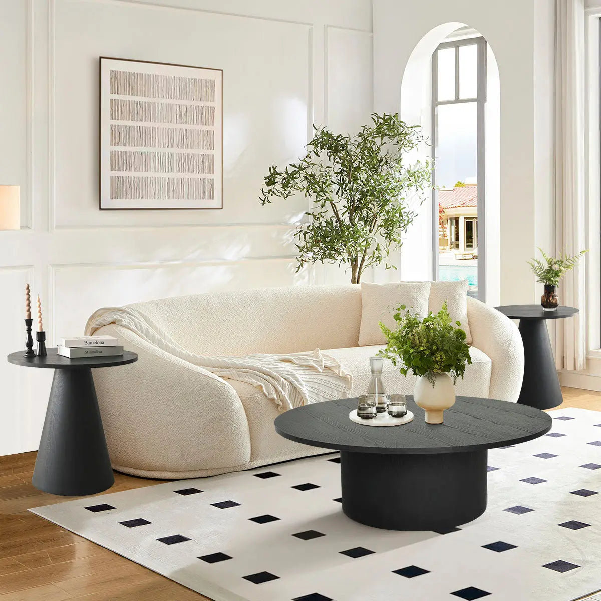 Dwen Black Round Table Set in living room, white sofa, wood flooring, geometric rug.