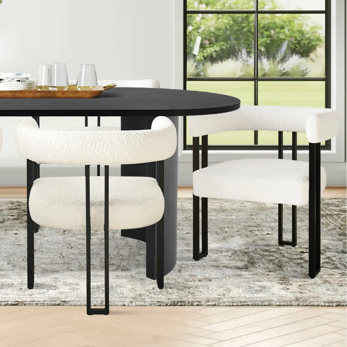 Modern black and beige oval dining table set, white chairs, gray rug, wooden floor, bright room.