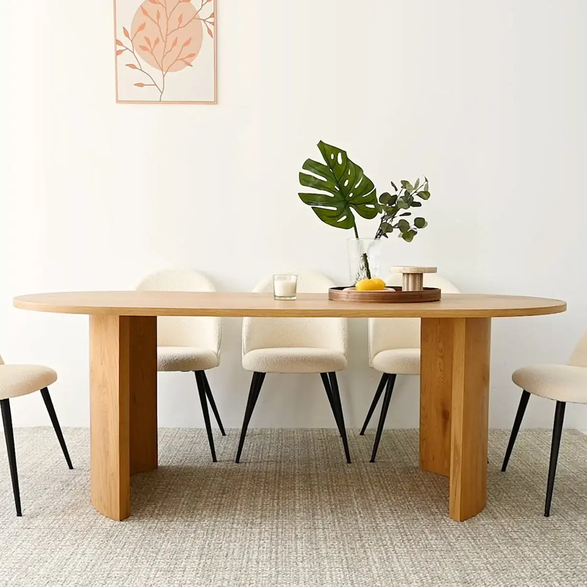 Dwen 79" oval dining table with beige chairs, modern decor, and minimalistic art in dining room.