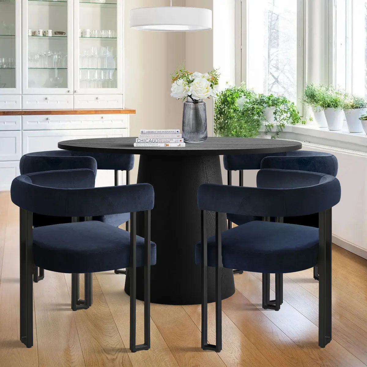 Dwen & Mia round black dining set with velvet chairs, white cabinets, wooden floor, bright kitchen.