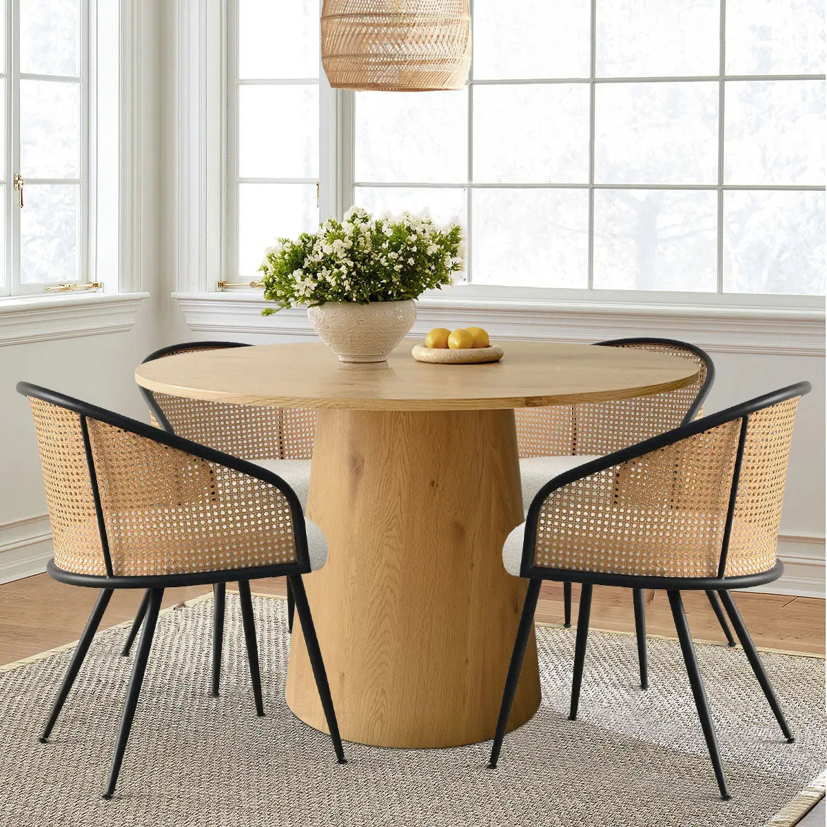 Dwen & Jules 46" Round Rattan Dining Set in sunlit room with white walls and wood flooring.