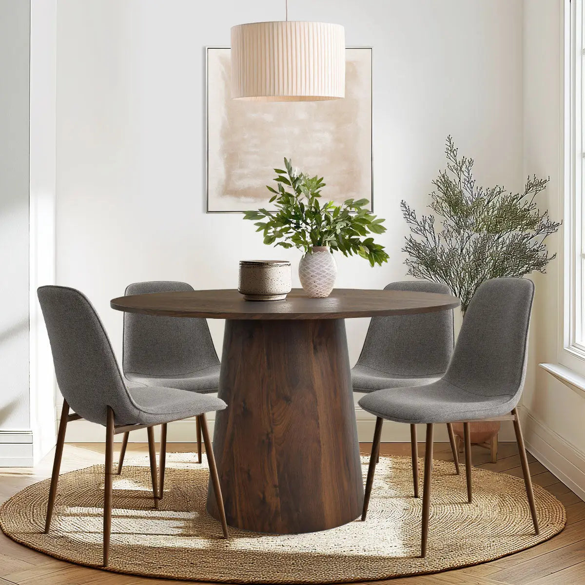 Dwen & Oslo dining table set with gray chairs, textured rug, white walls, and modern pendant light.