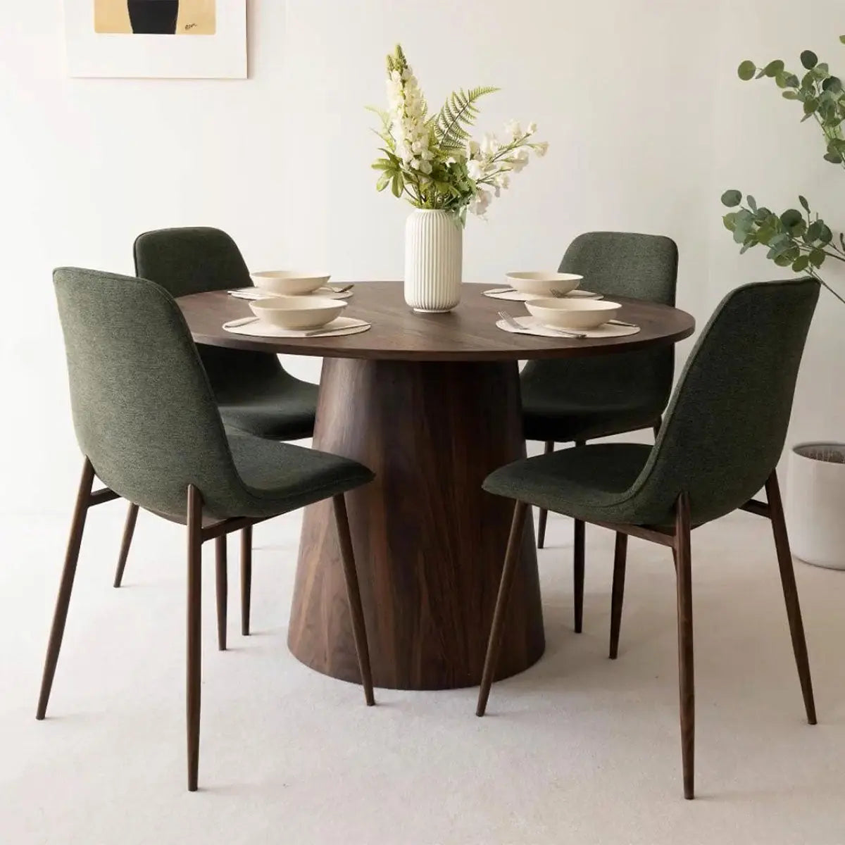 Modern dining table set by Dwen & Oslo with dark chairs, neutral walls, and soft carpet.