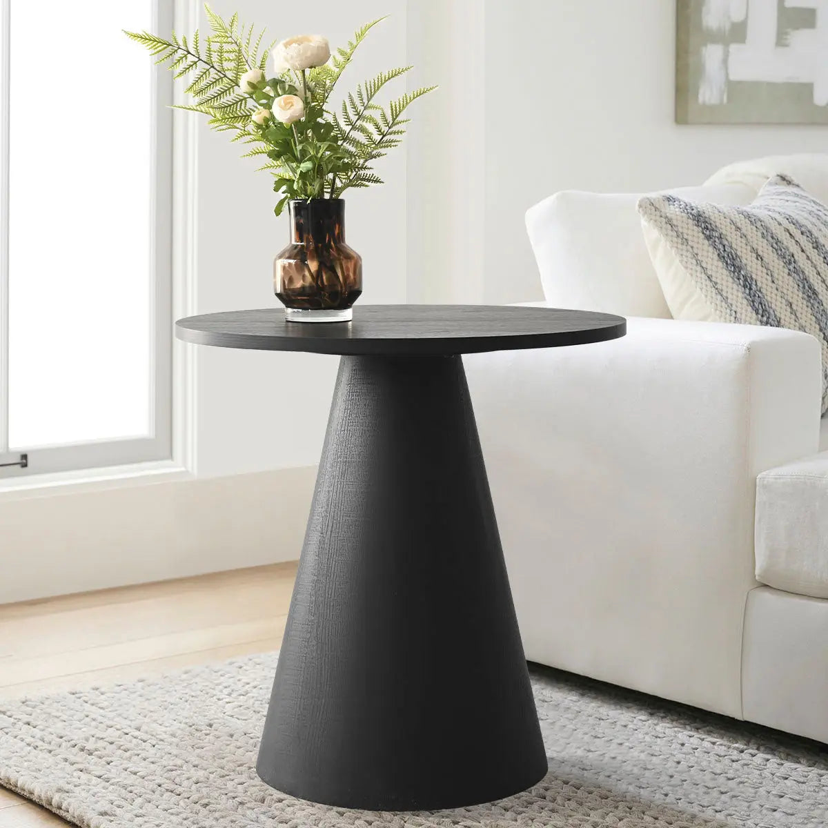 Dwen Modern Black Round Side Table in living room with white sofa, light wood flooring, neutral rug.