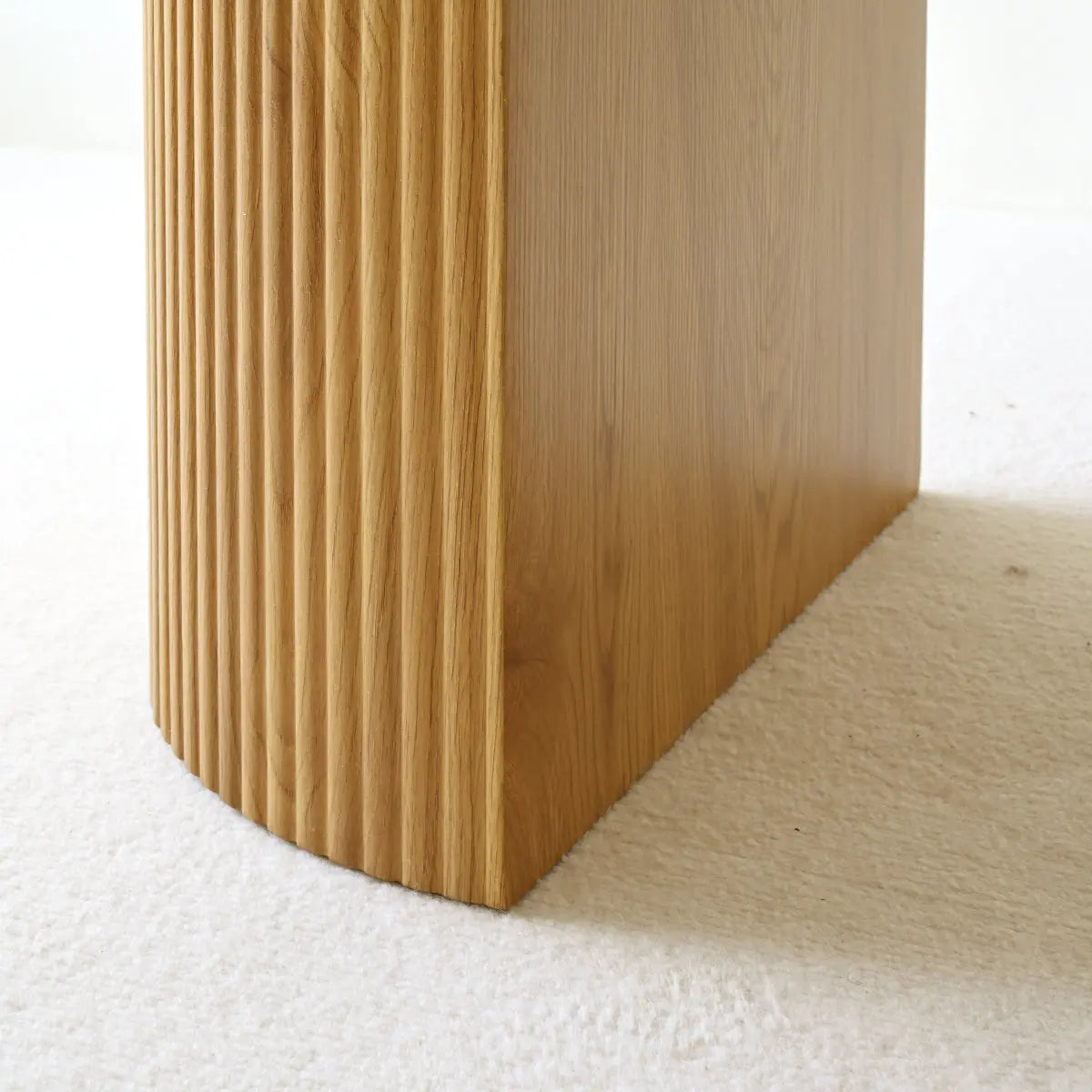 Close-up of Dwen Roman Pillar dining table on light carpet, showcasing textured wood finish.