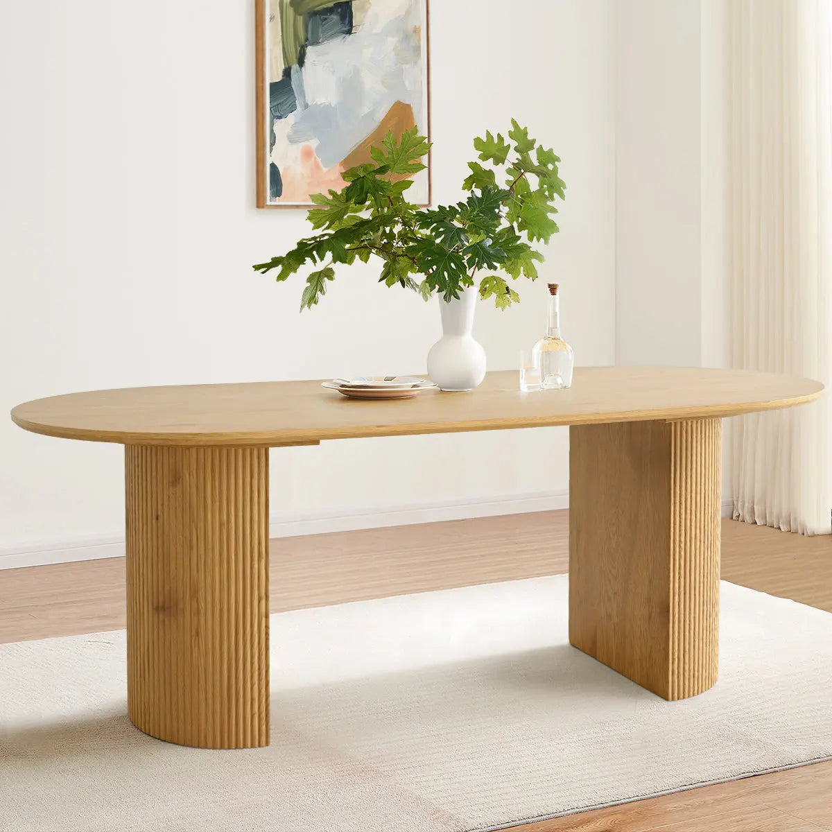 Dwen 79" Modern Oval Dining Table, Roman pillar design, light wood, white wall, beige rug.