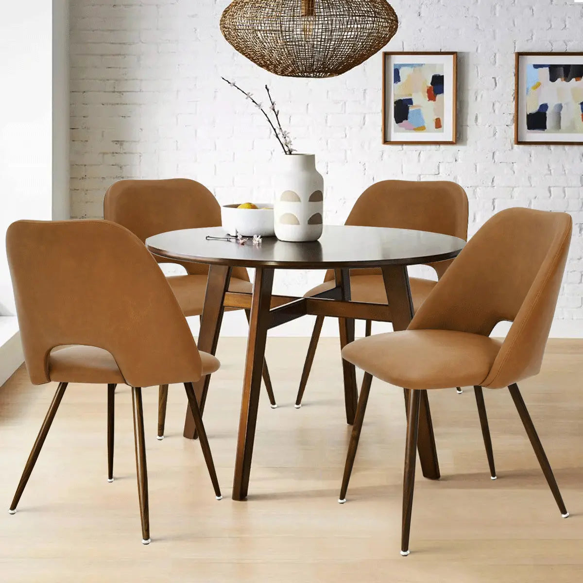 Edwin Modern Faux Leather chairs with round table, white brick wall, light wood flooring.