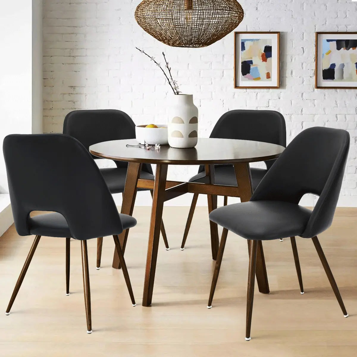 Edwin Modern Leather Dining Chair set by round table, white brick wall, light wood floor.