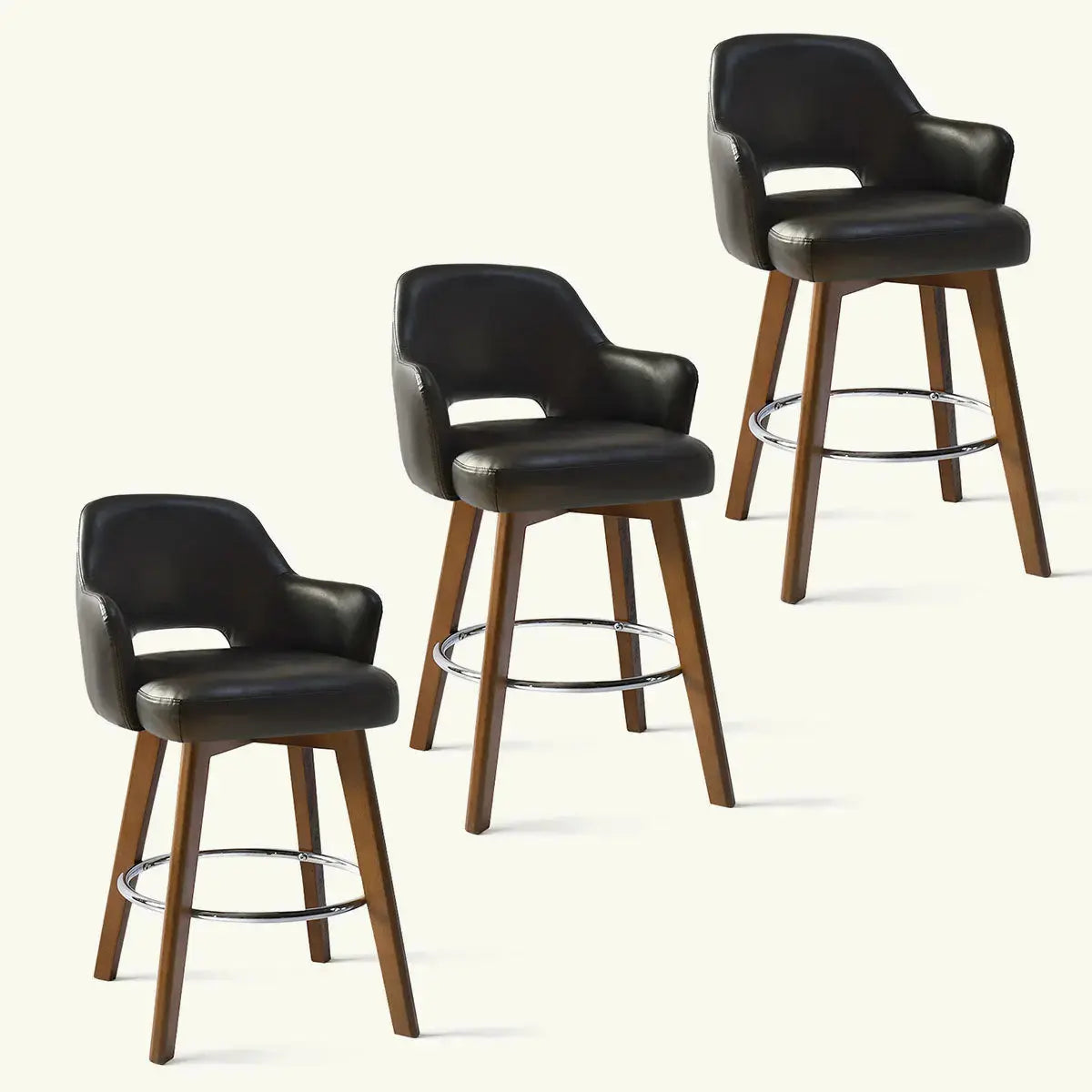 Three Edward Leather Swivel Counter Stools with Arms, black seat, wooden legs, chrome footrest.